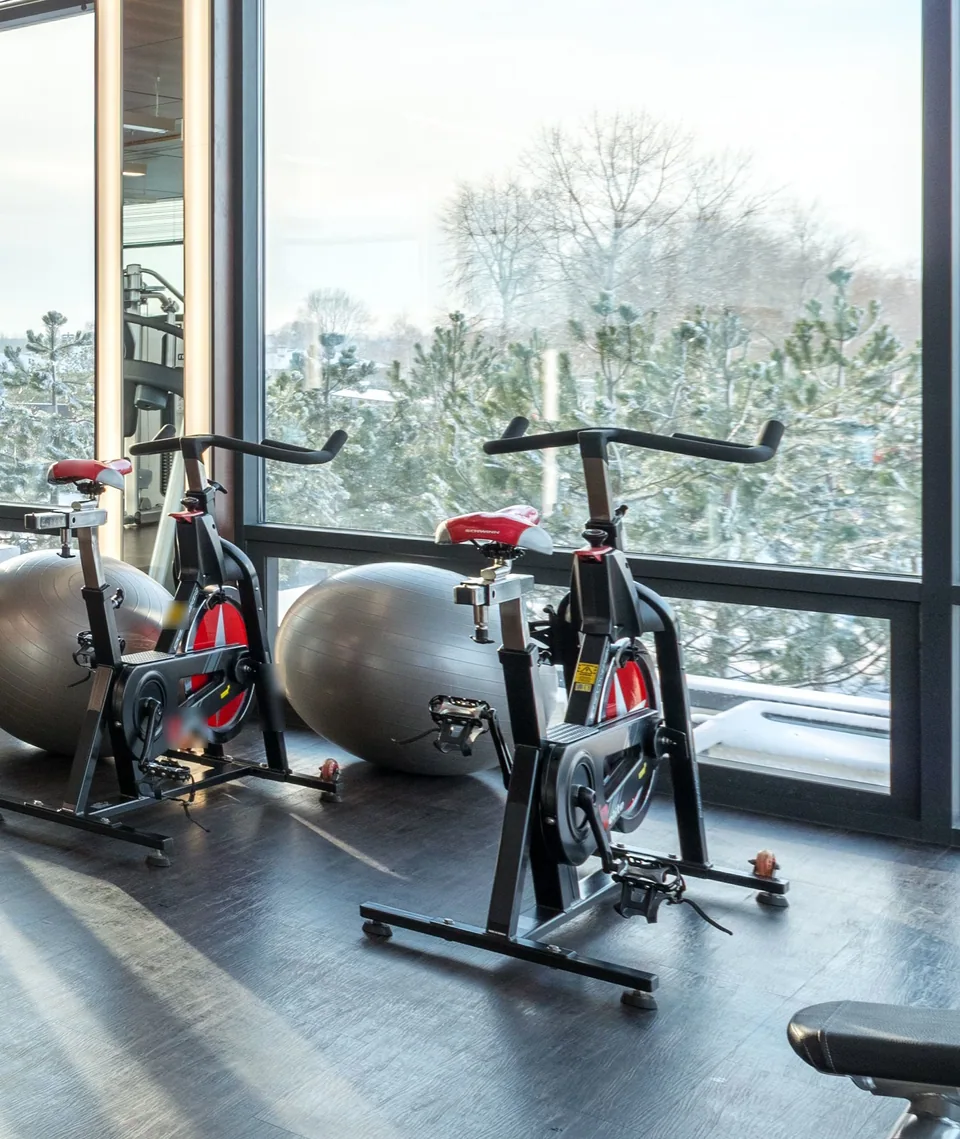 Bicis de ciclo indoor y fitballs junto a un ventanal