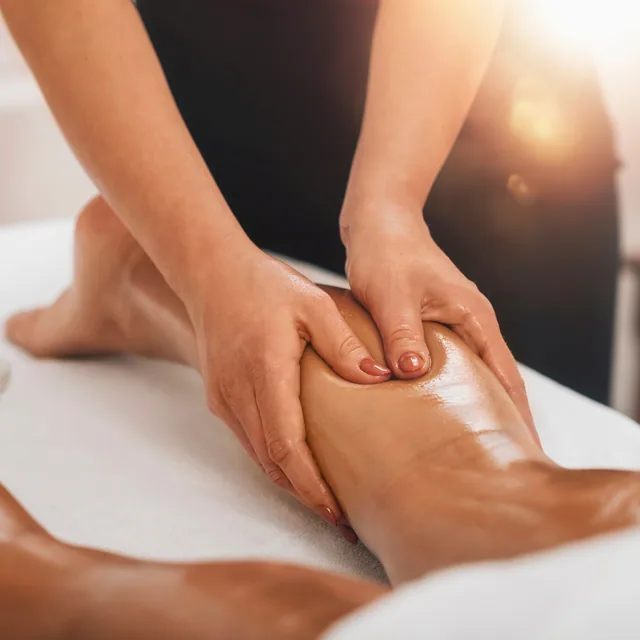 Manos de terapeuta masajeando la pierna