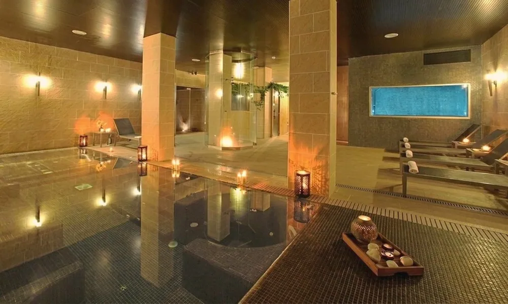 Indoor pool with candles and a tray of stones